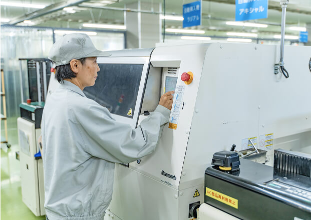ラジアル部品挿入機の段取り替えをしている写真